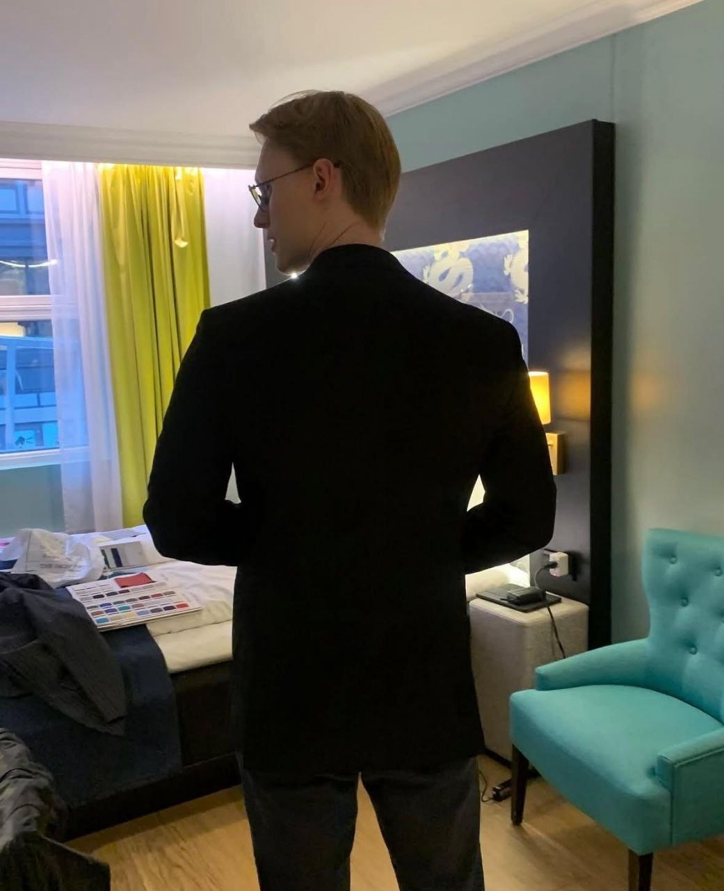 Real client photograph showing the back of a black jacket during a private fitting