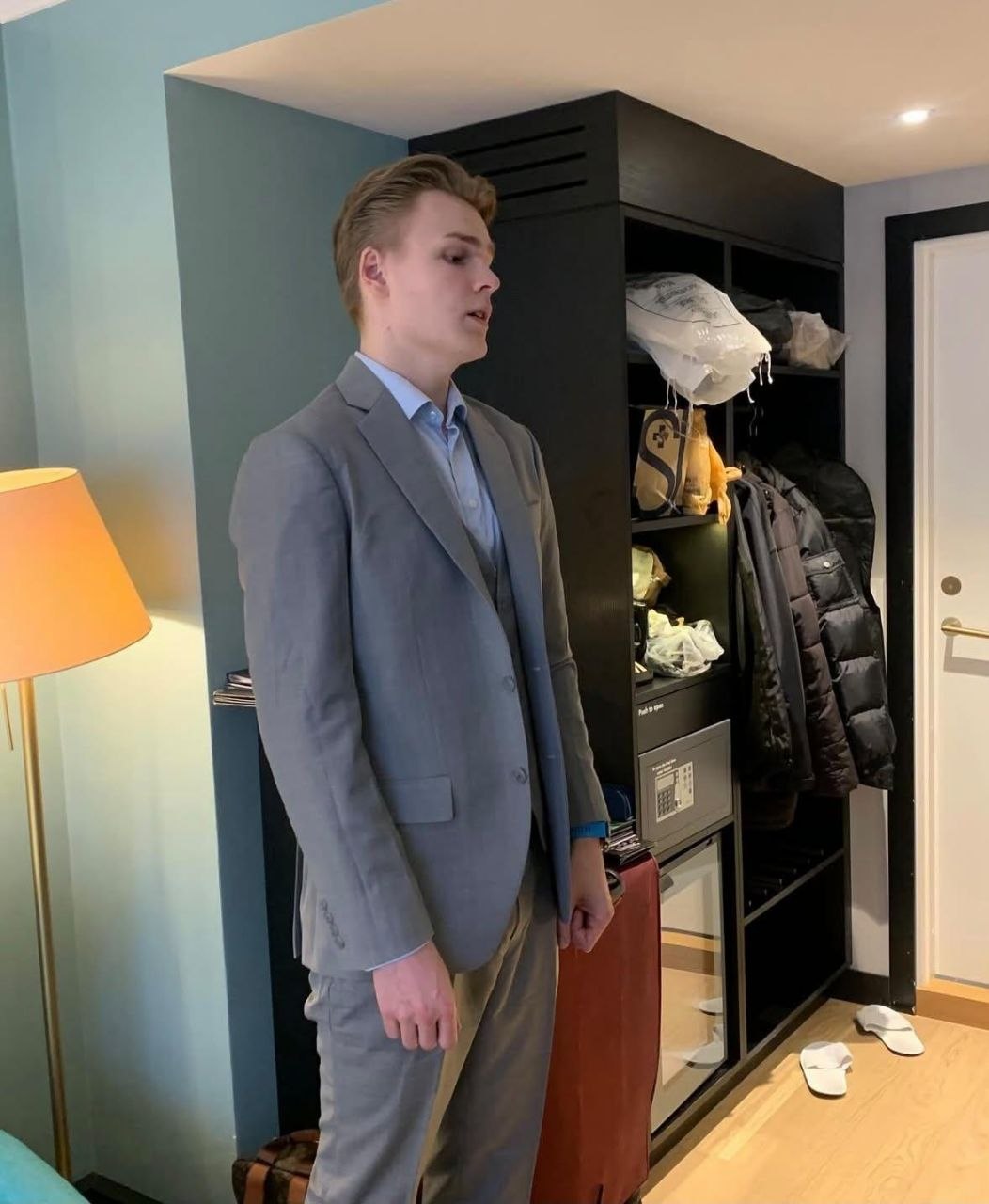 Real client photograph showing a light grey suit being reviewed in a private room